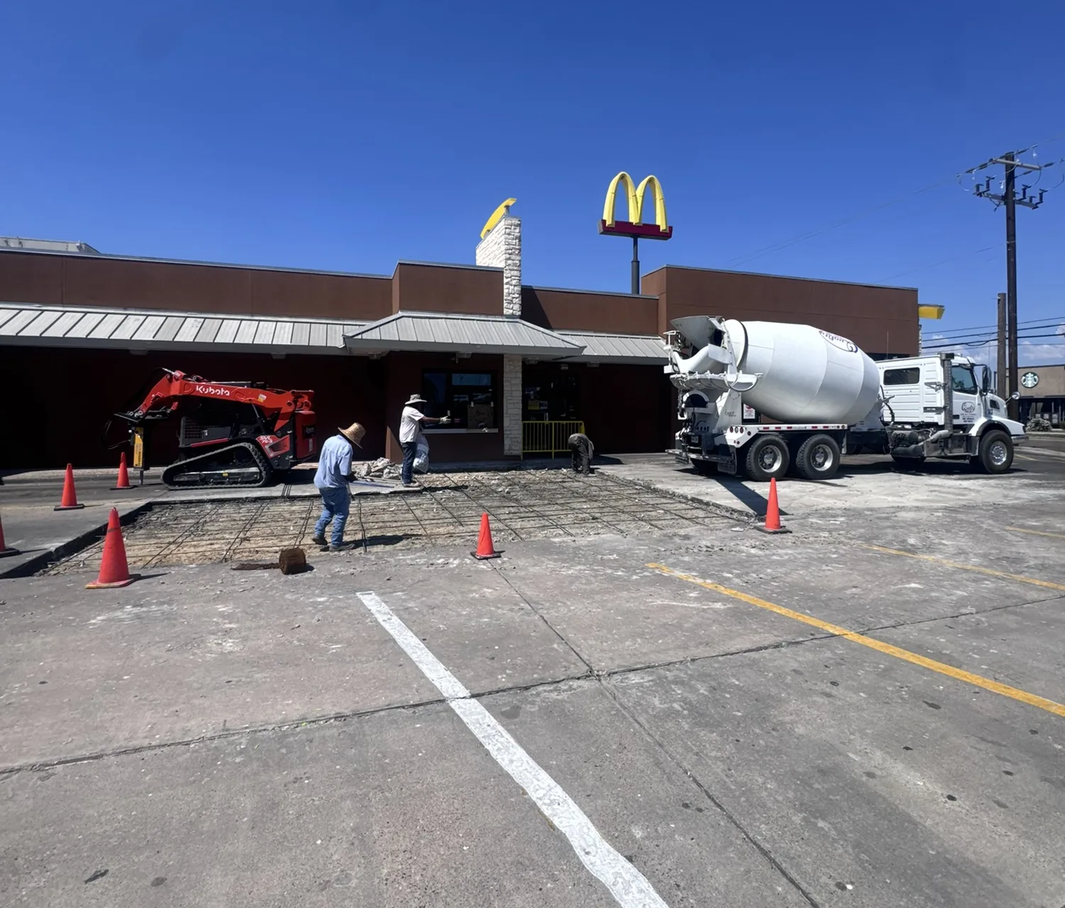 Commercial parking lot concrete pour at a McDonald's with a mixer truck on site by Billy's Concrete